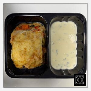 Lazanija su daržovėmis, užkepta kietuoju sūriu, pateikiama su sviesto-grietinės padažu