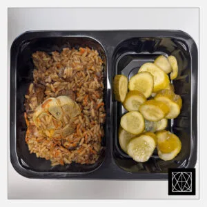 Kiaulienos plovas, pagardintas raugerškių uogomis, pateikiamas su marinuotais agurkais