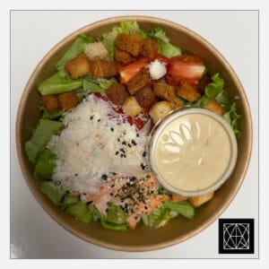 Cezario salotos su kepta lašiša, pomidorais, ančiuvių padažu, duonos skrebučiais ir parmezano sūriu