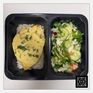 Vištienos kepsnys, užkeptas ananasais ir sūriu, pateikiamas su ryžiais ir šviežiomis salotomis