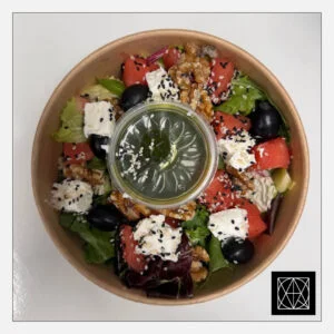 Graikiškos salotos su feta, arbūzu, graikiškais riešutais ir žaliuoju pesto padažu