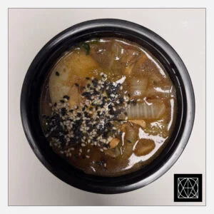 „Ramen/amen“ krevečių sultinys su vištiena, kiaušininiais makaronais, keptomis daržovėmis, šutintu kininiu kopūstu, marinuotu kiaušiniu, papuoštas kepintais sezamais ir svogūnų laiškais