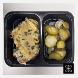 Kiauliena, užkepta šonine ir grybais, pateikiama su keptomis bulvėmis ir šviežiai raugintais agurkais