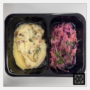 Kiauliena, užkepta šonine ir marinuotais agurkais, pateikiama su sviestine bulvių koše ir „Coleslaw“ salotomis