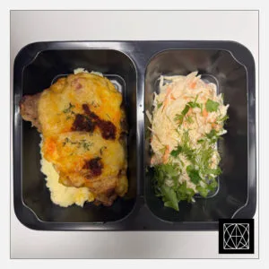 Kiaulienos sprandinė, užkepta čoriso dešra ir sūriu, pateikiama su bulvių koše ir šviežių kopūstų salotomis, gardintomis majonezu