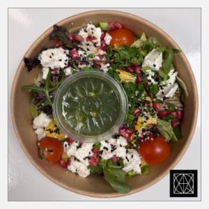 Salotos su ožkos sūriu, granatų sėklomis, keptu moliūgu ir žaliuoju pesto padažu