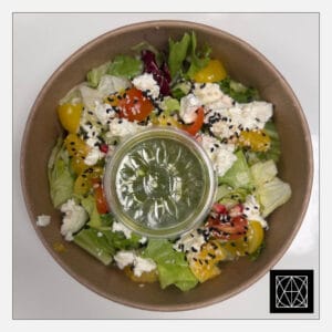 Salotos su feta, apelsinais, granatų sėklomis, vyšniniais pomidorais ir žaliuoju pesto padažu