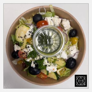 Graikiškos salotos su feta, alyvuogėmis, raudonuoju svogūnu, kepta cukinija ir žaliuoju padažu