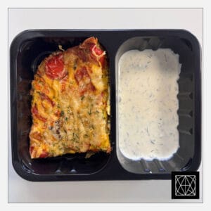 Vegetariškas daržovių omletas, gardintas kietuoju sūriu, pateikiamas su jogurtiniu padažu