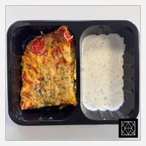 Vegetariškas daržovių omletas, gardintas kietuoju sūriu, pateikiamas su jogurtiniu padažu