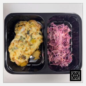 Kiaulienos kepsnys, užkeptas gražgarstėmis, porais ir sūriu, pateikiamas su keptomis česnakinėmis bulvėmis ir „Coleslaw“ salotomis