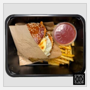 Mėsainis su gruzdinta vištiena, marinuotais agurkais, pomidorais, salotų lapais, svogūnais, čederio sūriu, česnakiniu majonezo padažu ir gruzdintomis bulvytėmis